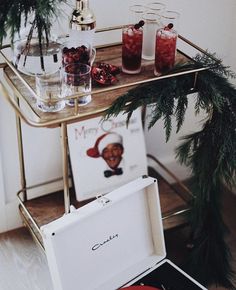 an open box sitting on top of a table next to christmas decorations and drinks in glasses