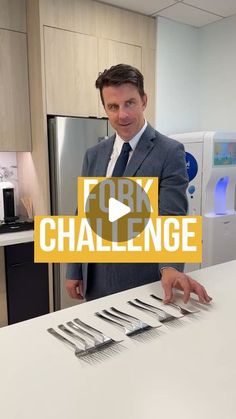 a man standing in front of a kitchen counter with forks and knives on top of it