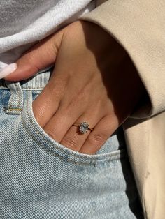 a close up of a person's hand with a diamond ring on their finger