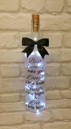 a lighted bottle with a black bow on it that says best friends make you laugh