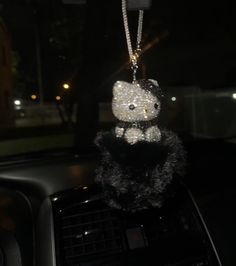 a car dashboard with a stuffed animal hanging from it's center console in the dark