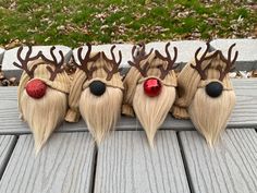 four reindeer wigs with red noses and long blonde hair sitting on a wooden deck