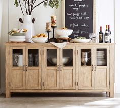 a buffet table with food and drinks on it in front of a chalkboard sign