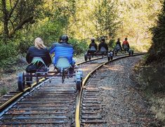 several people riding on the train tracks with their bikes down them and one person in a wheelchair behind them