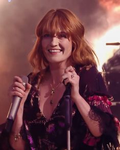 a woman with red hair holding a microphone