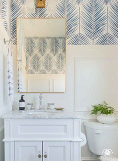 a white bathroom with blue and white wallpaper