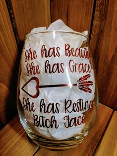 a wine glass that has been decorated with the words she has beauty, she has grace