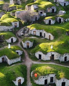 an aerial view of a group of buildings with grass roofs