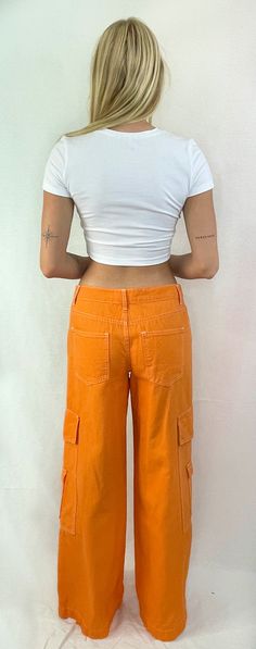 See things in color! These fun cotton cargo pants are the perfect trend in color. The flattering low-rise fit with wide legs and side snap pockets are just what you need to hit the streets. Pair this trend with a cute crop or your favorite tee and sneakers for a fun look. Color- Orange ( Also Available in Red) 100% Cotton Trendy Spring Cargo Jeans With Pockets, Trendy Spring Cargo Jeans, Trendy Summer Cargo Jeans With Multiple Pockets, Trendy Mid-rise Cargo Pants With Pockets, Urban Style Cotton Cargo Pants For Spring, Trendy Mid-rise Cargo Pants, Casual Mid-rise Cargo Pants For Summer, Spring Urban Cotton Cargo Pants, Spring Urban Style Cotton Cargo Pants