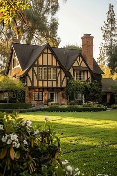 a large house sitting in the middle of a lush green field next to a forest