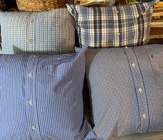 four pillows stacked on top of each other in front of a basket filled with books