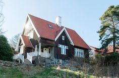 a large house with a red roof and white trim on the top of it's windows