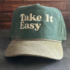 Vintage Style Take It Easy Embroidered Faded Canvas Snapback Trucker Rope Hat with Free Shipping. White stitched text/logo. Condition is "New with tags". Shipped with USPS First Class. Step into the world of the great outdoors with our Take It Easy Stitched Faded Canvas Rope Hat. With its faded canvas and rope accents, this hat exudes rustic charm. Plus, enjoy free shipping on this perfectly vintage-inspired accessory. *Condition is "New with tags". Shipped with USPS First Class. *This is a medi Vintage Curved Brim Hat With Letter Embroidery, Vintage Letter Print Snapback Hat For Outdoor, Vintage Snapback Hat With Letter Print For Outdoor, Vintage Snapback Baseball Cap With Letter Embroidery, Vintage Green Baseball Cap With Embroidered Logo, Vintage Outdoor Baseball Cap With Embroidered Logo, Vintage Adjustable Hat With Letter Embroidery, Vintage Adjustable Snapback Hat With Embroidered Logo, Vintage Hat With Embroidered Logo