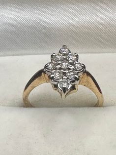 "Need to add a little sparkle to your life? This stunning 14K yellow gold diamond ring is the answer. The inside of the ring contains multiple markings including 14K along with an \"A015\" and \"EW\". This gorgeous cluster ring is a navette style, which means that it is more vertical than horizontal. There are nine round prong set 5-point diamonds for a total carat weight of just under 1/2 carat. .(45 tcw)  The setting measures 13.4mm x 9.3mm. and has tons of sparkle. It is a size 6 3/4 and weighs in at 3.12 g. It is the perfect ring for any occasion!" 14k Gold Cluster Diamond Ring With Prong Setting, Yellow Gold Diamond Cluster Ring For Anniversary, Yellow Gold Cluster Diamond Ring For Anniversary, Anniversary Yellow Gold Cluster Diamond Ring, 14k Gold Cluster Diamond Ring In Diamond White, 14k Gold Cluster Diamond Ring With Vvs Clarity, Cluster Diamond Ring Stamped 14k Gold, Formal Marquise Diamond Ring Stamped 14k, Heirloom 14k Gold Diamond Cluster Ring