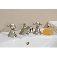 two faucets are sitting on the sink in front of towels and orange slices