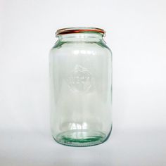 a glass jar with a red lid on a white background