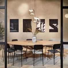 a round wooden table surrounded by black chairs