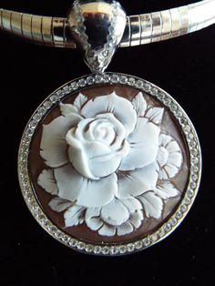 "This is an amazing cameo bezel set in Italian silver with a permanent bail (8mm). The bezel setting and bail have cz's encrusted around the entire rose cameo. It is carved in sardonyx shell and measures 35 mm (1.37\") round. This a beautiful piece to give as a gift or for yourself. It is carved by our carver, Romano. This pendant comes with a 18\" stainless steel chain. This is a rose that will live forever! This pendant comes with a black velvet box and certificate of authenticity. Item Number Luxury Cameo Jewelry, Luxury White Gold Cameo Jewelry, Luxury Silver Cameo Jewelry, Live Forever, Steel Chain, Stainless Steel Chain, A Rose, Certificate Of Authenticity, Bezel Setting