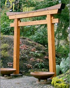 two wooden benches sitting under an arch in the middle of a garden with moss growing on the ground