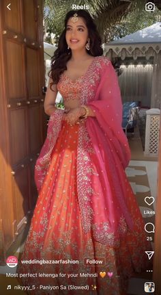 a woman in an orange and pink lehenga