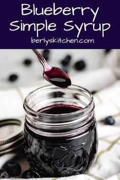 blueberry simple syrup in a mason jar with a spoon full of liquid on the side