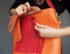 "Original bright leather shoulder hobo bag made of quality natural leather in orange and red color color. Comfortable and durable, it is designed it to be your perfect everyday bag, The red fringe is detachable and the strap has two sides - red and orange. You can wear it two colored and orange only depending on your outfit. The bag features zipper closure, one big inside compartment and leather slip pocket. You won't be unnoticed with this bag! Size: height - 13\"/ 34 cm width - 13\"/ 34 cm dep Orange Bucket Bag With Detachable Handle, Orange Bucket Bag With Removable Pouch For Shopping, Orange Hobo Shoulder Bag, Orange Leather Bucket Shoulder Bag, Orange Leather Shoulder Bucket Bag, Orange Hobo Bag With Removable Pouch For Shopping, Orange Leather Hobo Bag For Daily Use, Orange Leather Bucket Bag For Shopping, Orange Leather Hobo Bag