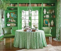 a dining room with green walls and furniture