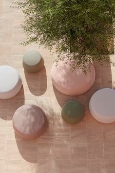 an overhead view of several different colored stools and a plant in a pot on the ground