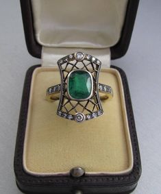 Art Deco emerald ring with diamonds, made of 14K gold and silver. With a Hungarian 14K hallmark that was used after 2016. The top part is made of silver. The head part of the ring is 0.796 inches (20 mm) long. Gemstone: one piece of emerald, 1.54 carat, its size is: 0.24 inches * 0.31 inches (6.1 mm * 7.8 mm) The emerald has inclusions which unfortunately affects the surface of the stone as well. I tried to make photos of that. Additional gemstone details: 20 single cut diamonds Carat weight: 0. Elegant 14k Stamped Emerald Ring, Art Deco Emerald Diamond Ring With Accents, Antique Emerald Cut Yellow Gold Emerald Ring, Antique Green Oval Diamond Ring, Art Deco Emerald Ring With Rose Cut Diamonds, Art Deco Green Emerald Ring With Rose Cut Diamonds, Antique Green Ring With 17 Jewels, Antique Green Diamond Ring With Rose Cut Diamonds, Antique Green Diamond Ring With Rose Cut