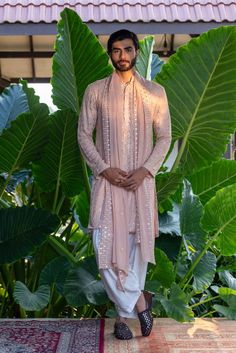 For day-long wedding festivities, a dapper muted pink kurta set from Bohame is a must-have. The exquisite thread embroidery and eye-catching mirror work amplifies this charming outfit, ensuring it captures hearts. Explore more from the label at our website from an exclusive curation, Baraat: The Groom's Edit. #Perniaspopupshopmen #menswear #ethnic #whatiworewastrending #ppuslove #Bohame #kurtaset Haldi Dress For Groom, Traditional Indian Mens Clothing, Haldi Outfit, Pink Kurta