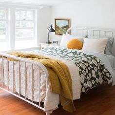 a white bed sitting in a bedroom next to a window