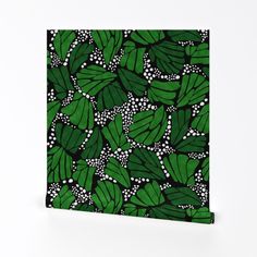 a painting of green leaves on black and white paper with dots in the center, against a white background