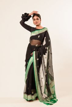 Embrace timeless elegance with our handwoven Banarasi masterpiece, the pure khaddi georgette saree. The dramatic black hue paired with a vibrant green border creates a look of sophistication. Designed to flow gracefully with every step, this saree exudes charm and allure, perfect for any occasion. Designer Black Banarasi Silk Saree, Black Bollywood Handloom Pre-draped Saree, Black Silk Handloom Pre-draped Saree, Black Silk Pre-draped Saree With Zari Weaving, Black Dupatta With Zari Weaving For Designer Wear, Black Banarasi Silk Pre-draped Saree With Pallu, Black Traditional Wear With Zari Weaving For Designer Wear, Black Traditional Wear With Zari Weaving For Designer Occasions, Black Banarasi Silk Pre-draped Bollywood Saree