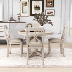 a dining room table with four chairs and pictures on the wall above it, along with a white rug