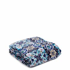 the blue and white floral print blanket is folded up on top of each other,