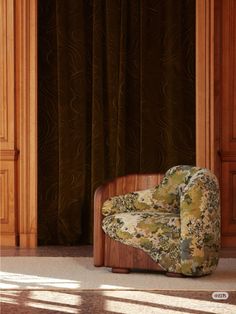 a chair that is sitting in front of a curtain