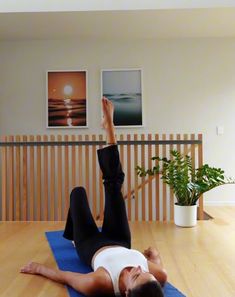 a woman laying on the floor with her legs up in the air while doing yoga