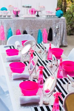 the table is set up with pink and white dishes