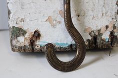 an old metal hook on the side of a wall