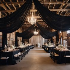 an elegantly decorated banquet hall with chandeliers and black draping on the ceiling