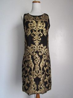 "This is a Glamorous Vintage Modern 1963DEX Made in INDIA Black Polyester and Golden Metallic Gold Sequin Embellished Shift Knee Midi Dress Cocktail Party Evening Special Occasion Size S M The style is a fully lined, shift dress with side invisible zipper, and heavily embellished metallic gold knee sequins front and back (never sit on sequins!). condition there is 1 very tiny hole/cut on the side of the dress, but it's not obvious, only if you stare at it really closely. Other than that, this lo Black Evening Dress With Gold Embroidery, Black Dress With Gold Embroidery For Party, Black Dress With Gold Embroidery For Festive Occasion, Festive Black Dress With Gold Embroidery, Black Sleeveless Festive Dress, Festive Sleeveless Black Dress, Festive Black Sleeveless Dress, Gold Embroidered Sleeveless Dress, Slim Aarons