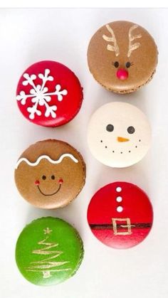 four decorated cookies sitting next to each other on top of a white surface with snowflakes