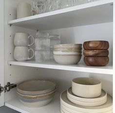 white dishes and bowls on shelves in a kitchen