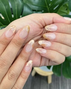 a woman's hands with french manies and nail polish on them, next to a plant