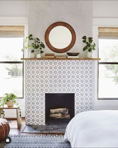 a bedroom with a fireplace and mirror above it