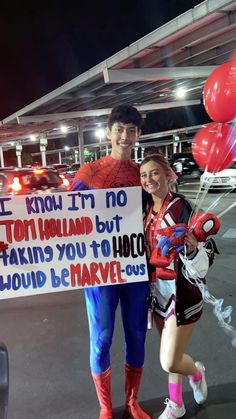 two people standing next to each other holding a sign