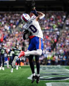 a football player jumping in the air to catch a ball