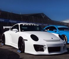 two white sports cars parked next to each other