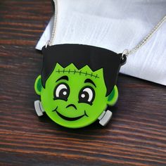 "A delicately handcrafted acrylic brooch, guaranteed to make a statement.  💚 Made from smooth glossy lime green, grey, black and white acrylics. 🔩 The details on his face, ears and neck bolts have been laser-etched and hand-inked in black, white and green paints. ⚡ The accompanying chain is approx 18\" in length, and also free from Nickel or Lead. 💀 Measurements are: 4.5cm (h) x 4.5cm (w) 💚 Your necklace will arrive displayed on a branded backing card inside a clear protective wallet. 🔩 For Black And White Acrylics, Cute Frankenstein, Unique Best Friend Gifts, Kawaii Monster, Acrylic Brooch, Halloween Items, Friend Gifts, Backing Card, Necklace Statement