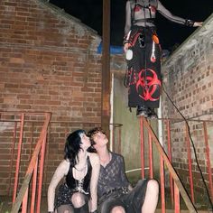 two women are sitting on the stairs with their mouths open and one is wearing a costume